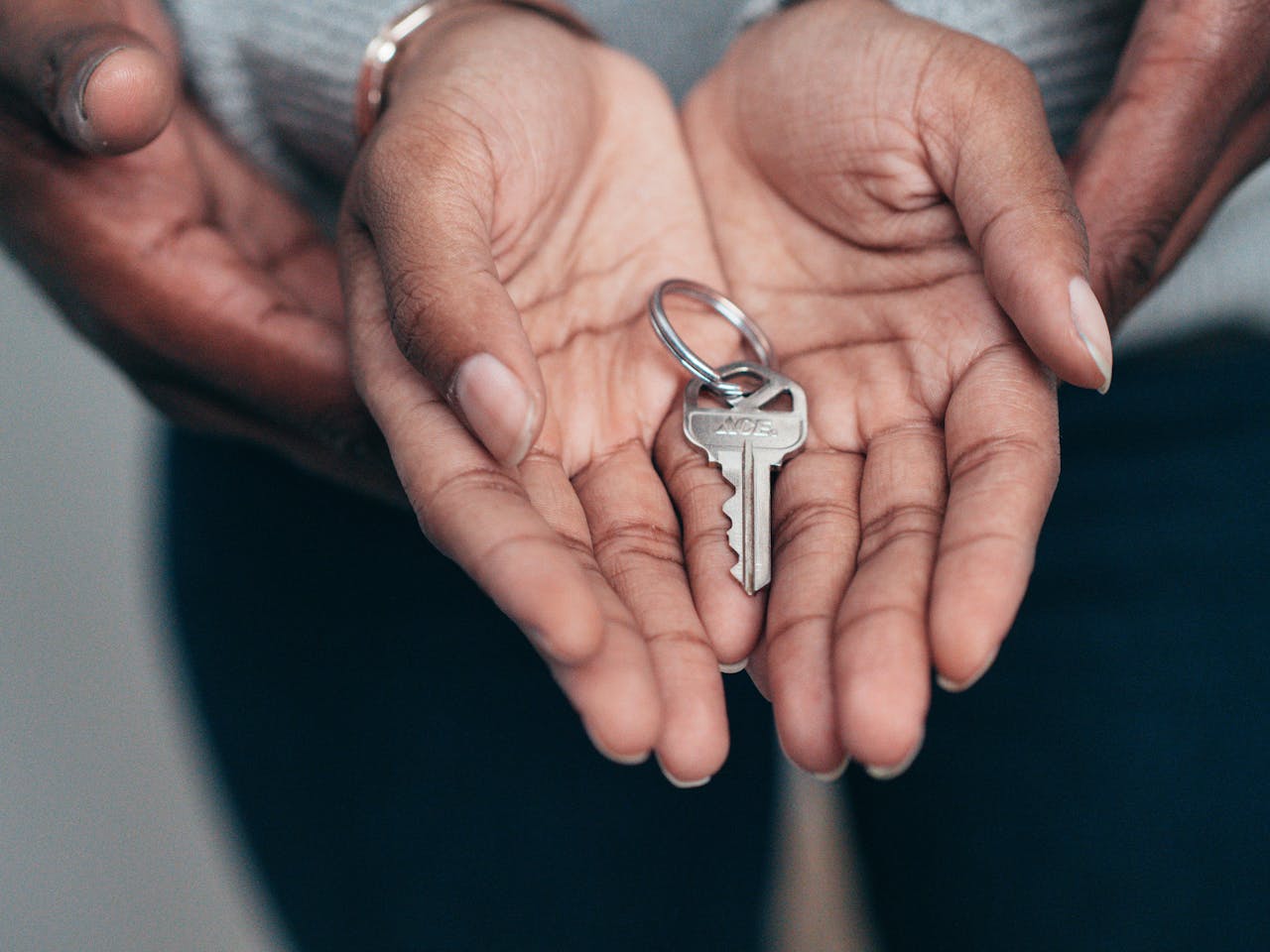 about-img Close-up of hands holding a key, symbolizing homeownership, real estate, and property investment.